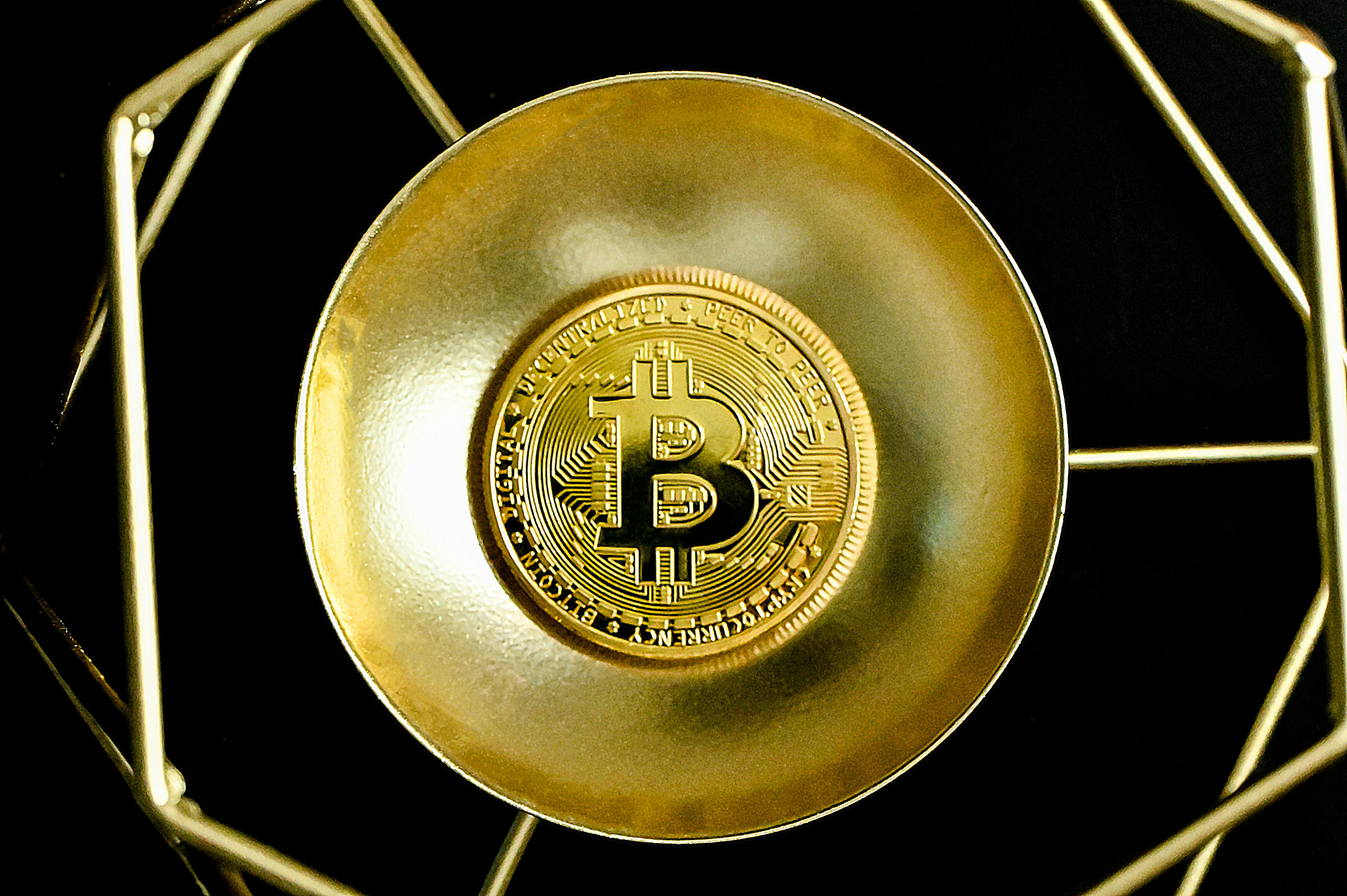 A single Bitcoin placed on a golden bowl