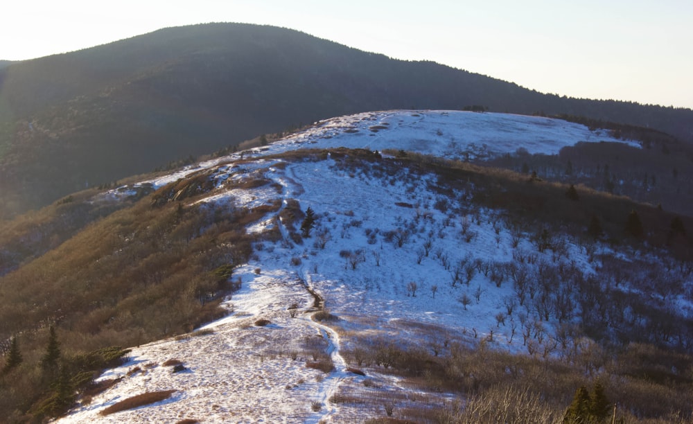 a snow covered mountain with a trail going up the side of it