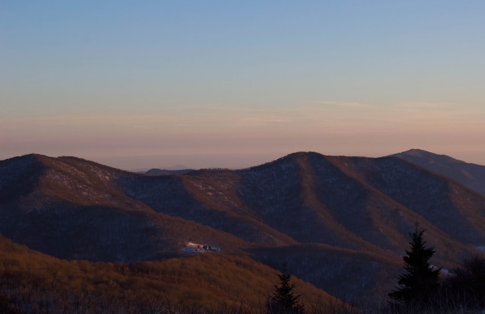 a view of a mountain range with a house in the distance