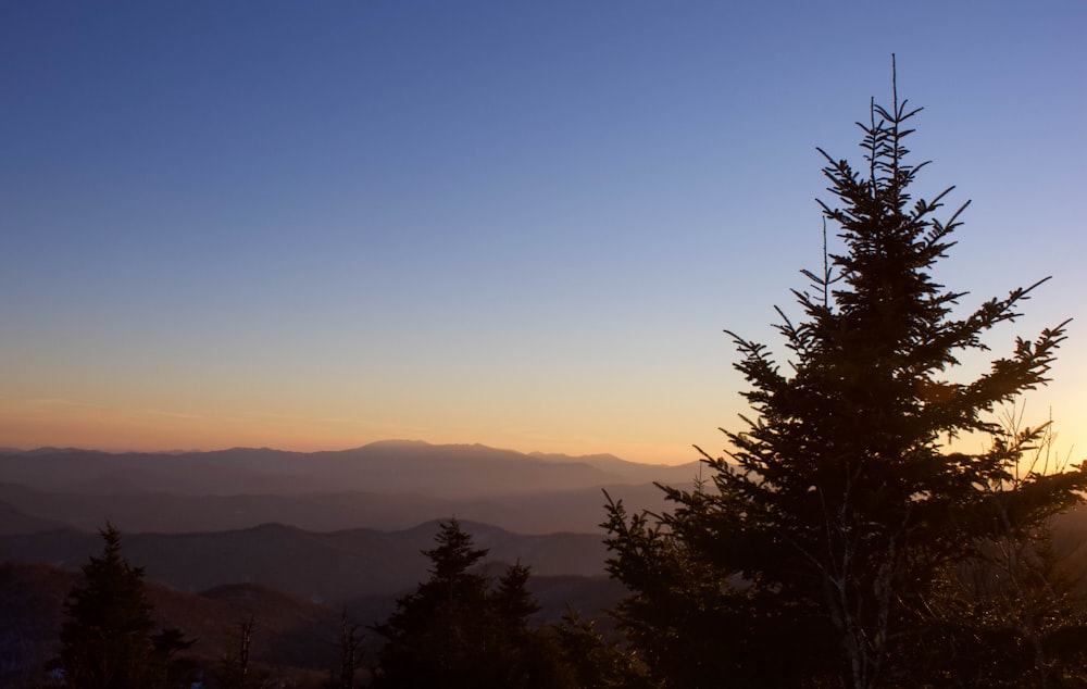 the sun is setting over a mountain range