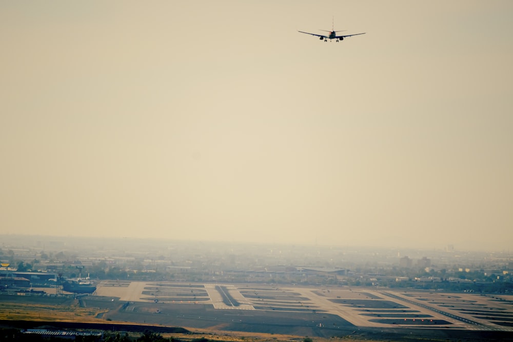 an airplane is flying over a large airport