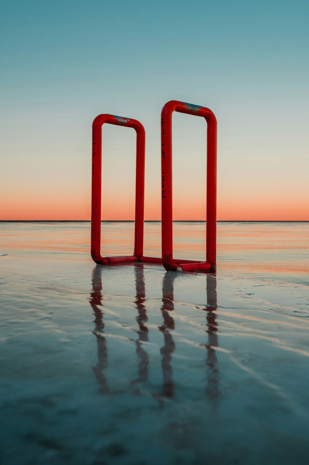 a couple of red objects sitting on top of a beach