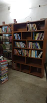 A professional assembling a wooden bookshelf in a bright room.