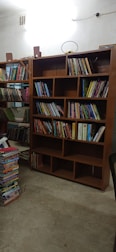 Professional assembling a wooden bookshelf in a bright room.