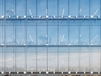 a tall glass building with a sky in the background
