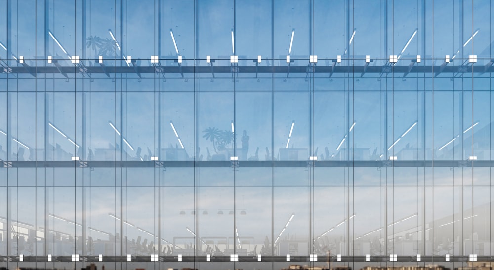 a tall glass building with a sky in the background