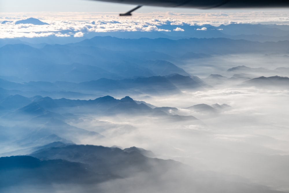 an airplane wing flying over a mountain range