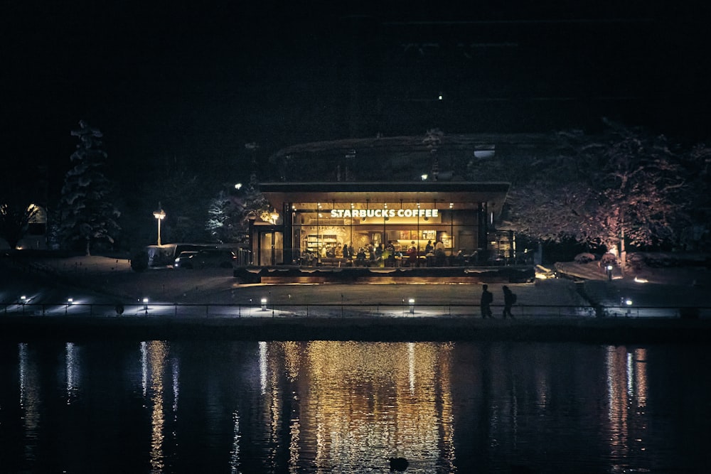 a night scene of a coffee shop by the water