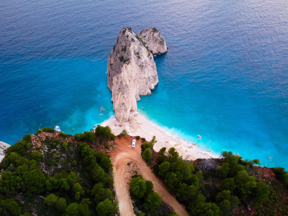 an aerial view of a beach and a rock formation