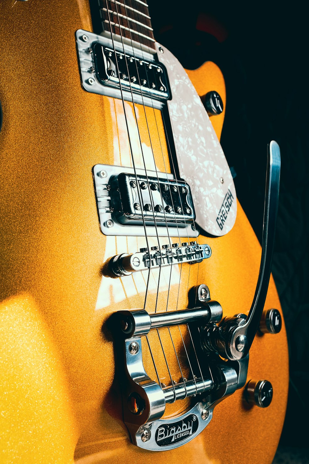 a close up of a yellow electric guitar