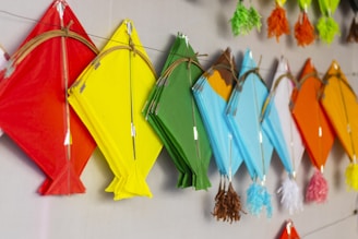 a group of colorful kites hanging on a wall