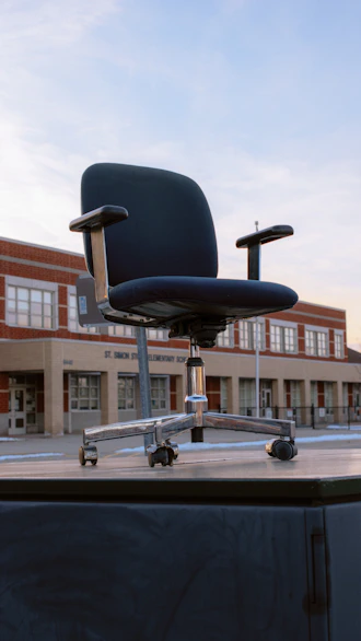an office chair sitting on top of a wooden table