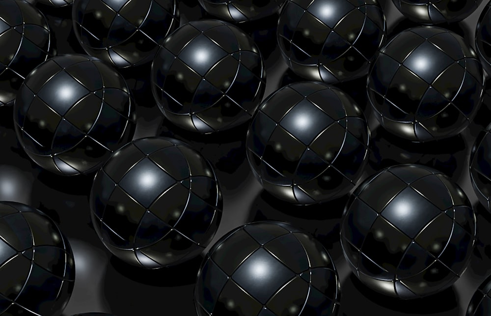 a bunch of black balls with a black background