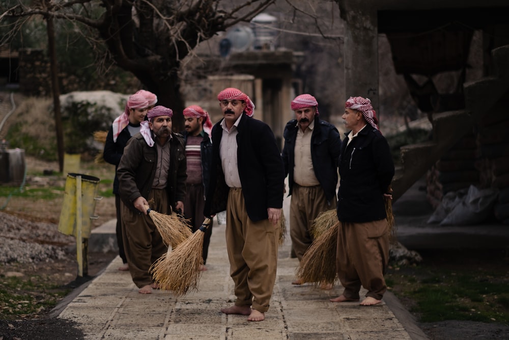 a group of men walking down a sidewalk