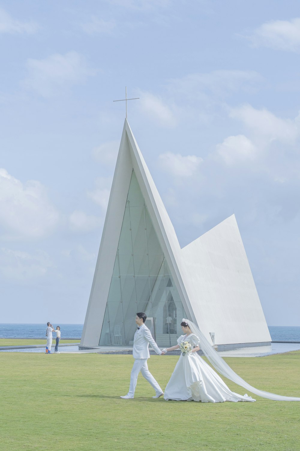 a bride and groom walking in front of a church