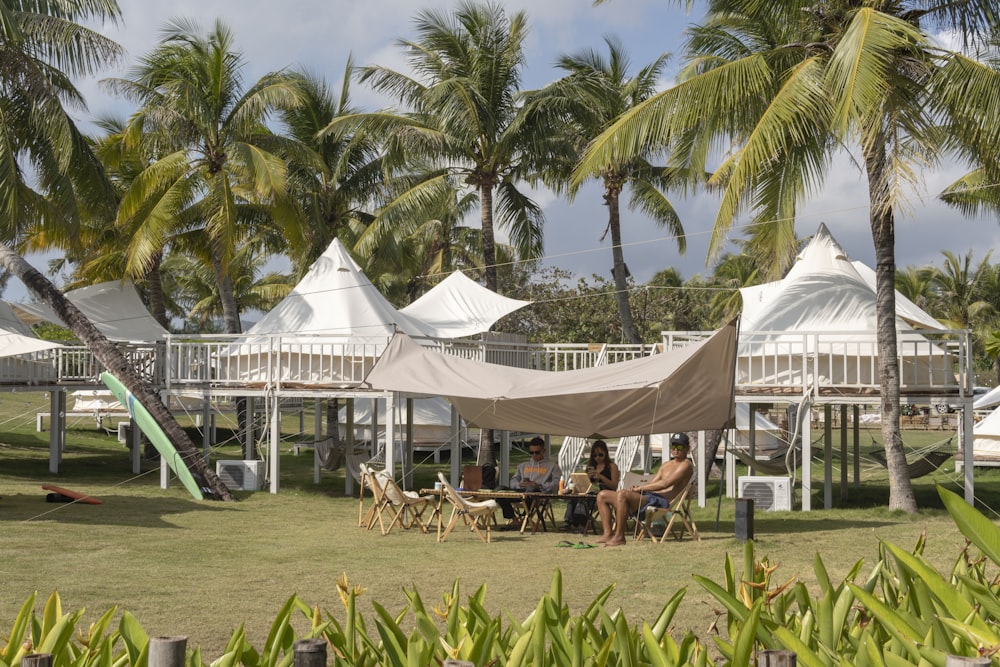 a group of people sitting at a table under a tent