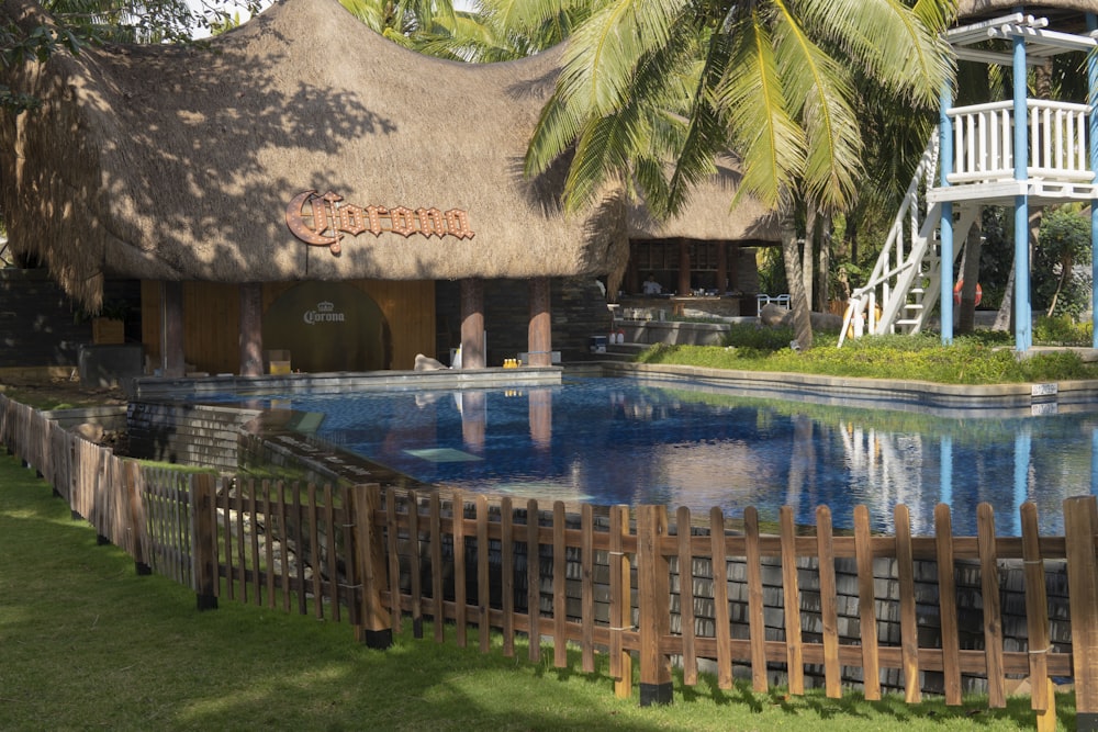 a house with a thatched roof next to a pool
