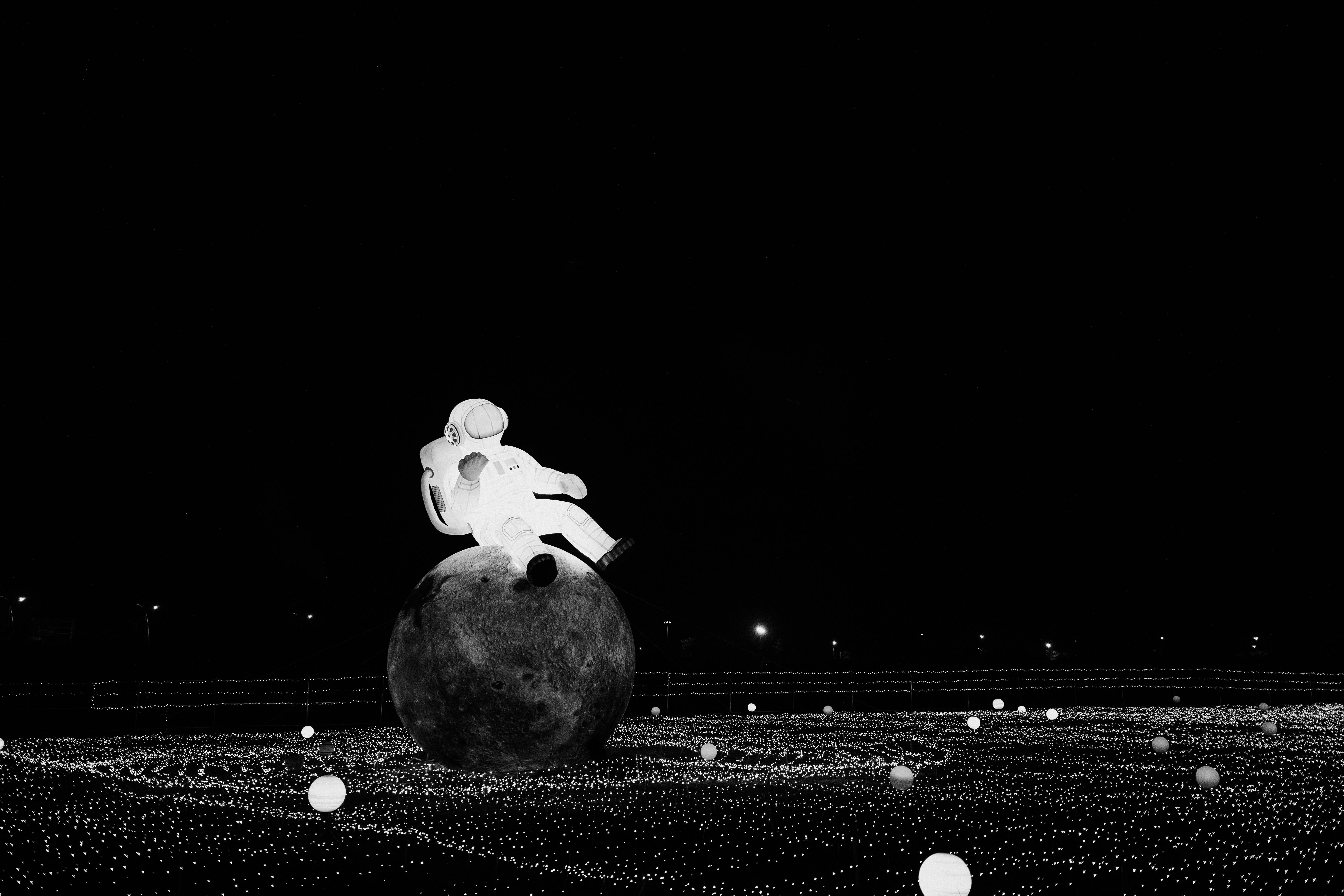 a black and white photo of a person sitting on top of a ball