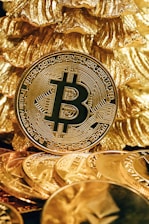 a bitcoin sitting on top of a pile of gold coins