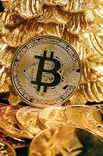 a bitcoin sitting on top of a pile of gold coins