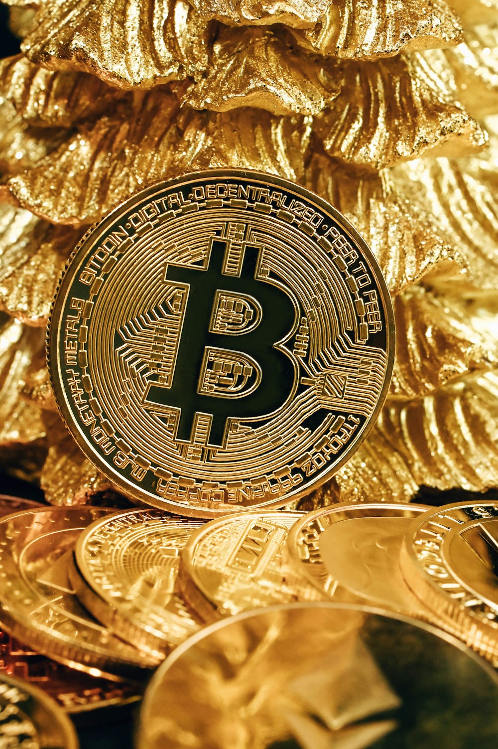 Un bitcoin assis sur une pile de pièces d’or