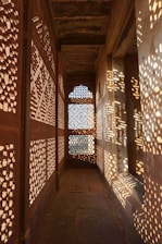 a long hallway with intricate carved screens on the walls