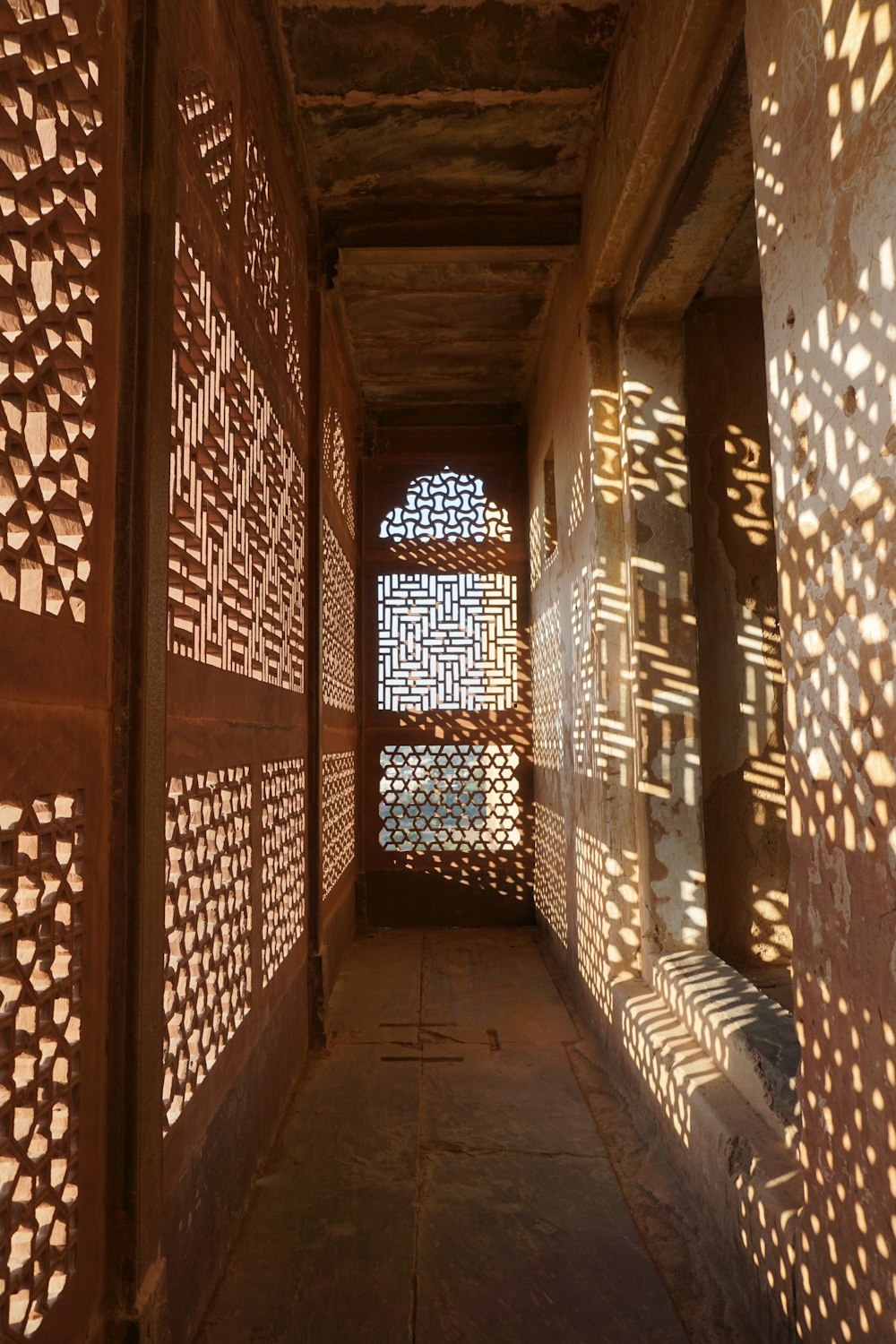 a long hallway with intricate carved screens on the walls