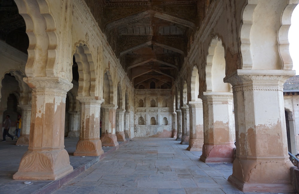 a long hallway with stone pillars and arches