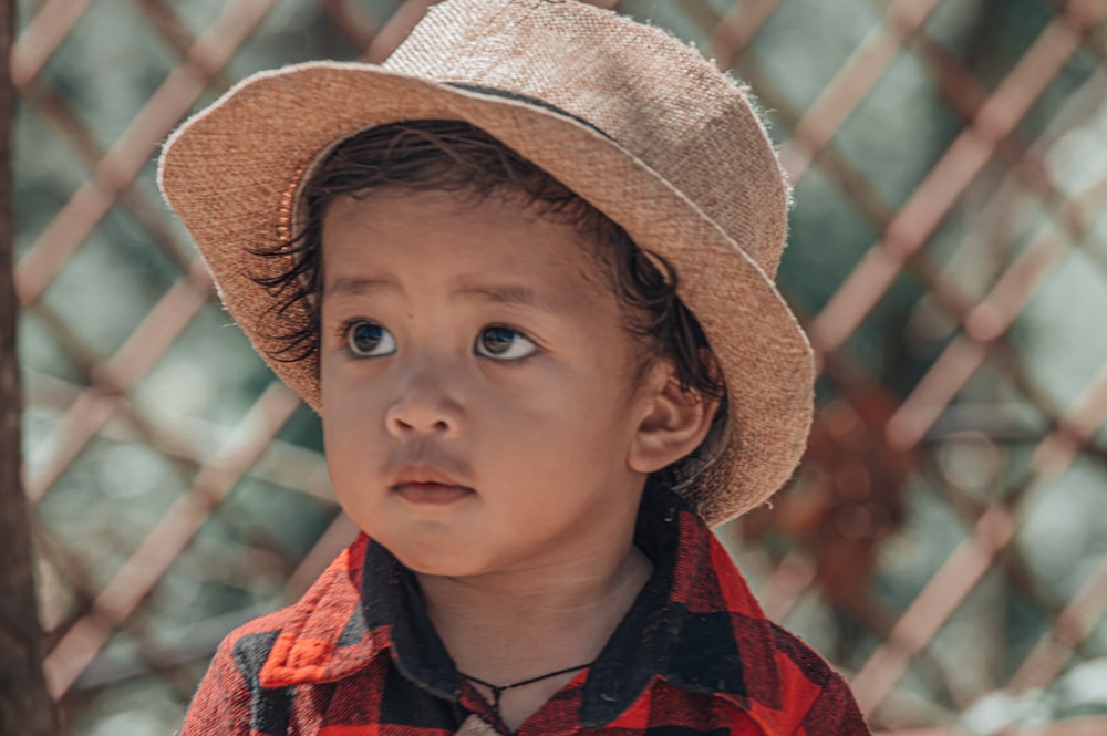 a young boy wearing a hat and looking up