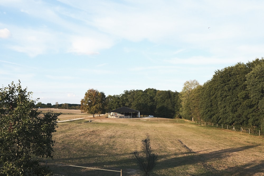 Un gran campo abierto con una casa en la distancia