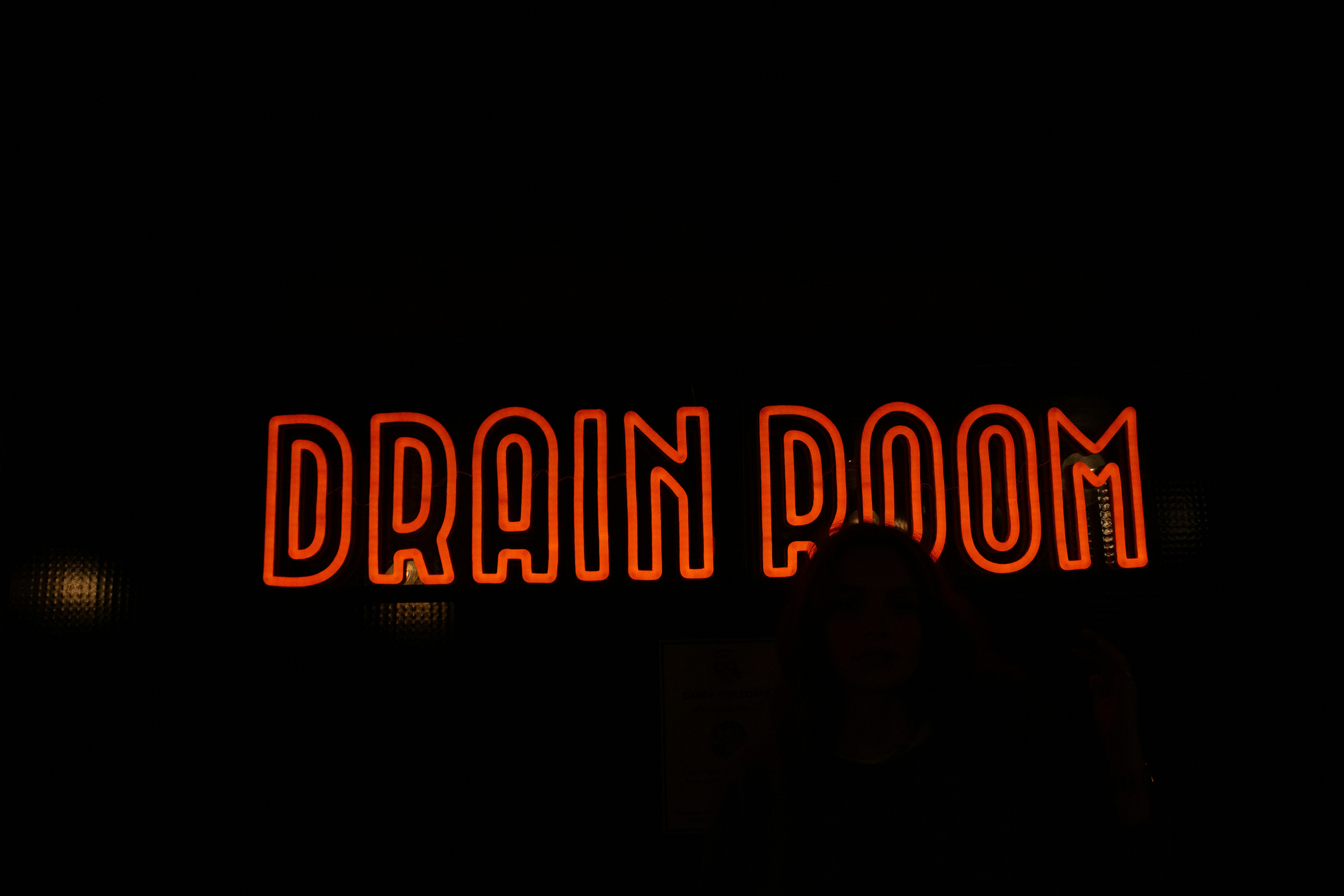 Une femme debout devant une enseigne au néon