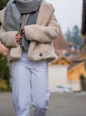 A cozy autumn outfit featuring a long skirt, layered cardigan, and soft scarf in warm tones.