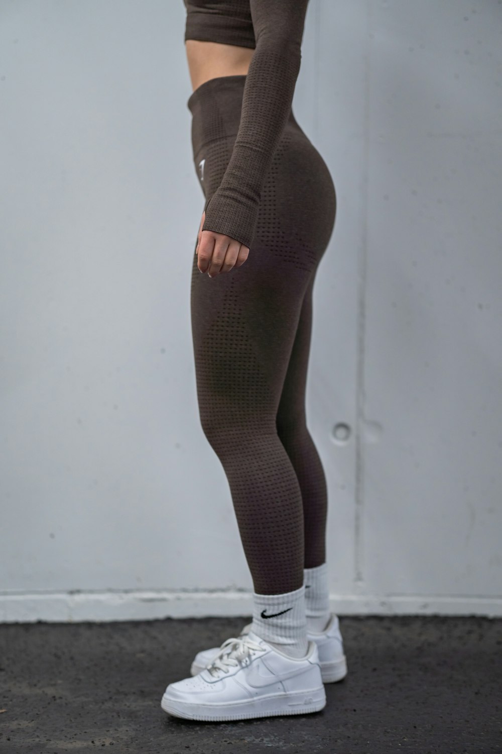 a woman in a brown top and leggings