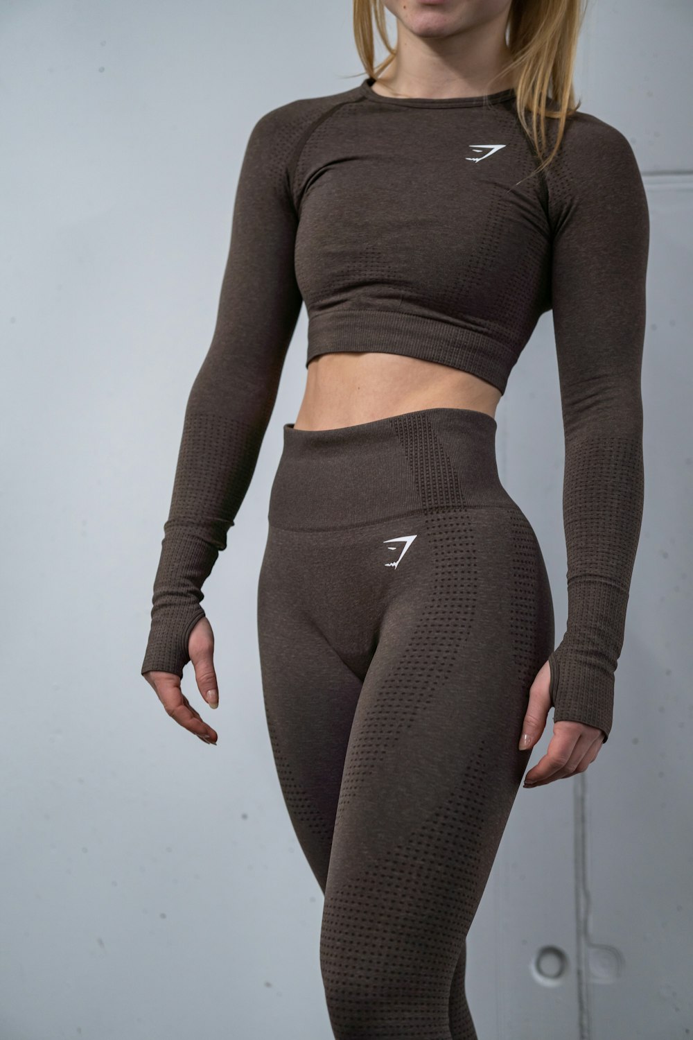 a woman in a brown top and leggings