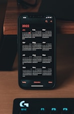 a phone sitting on top of a desk next to a keyboard