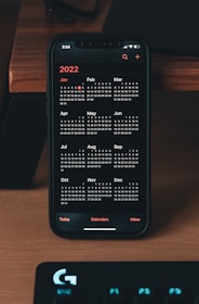 a phone sitting on top of a desk next to a keyboard