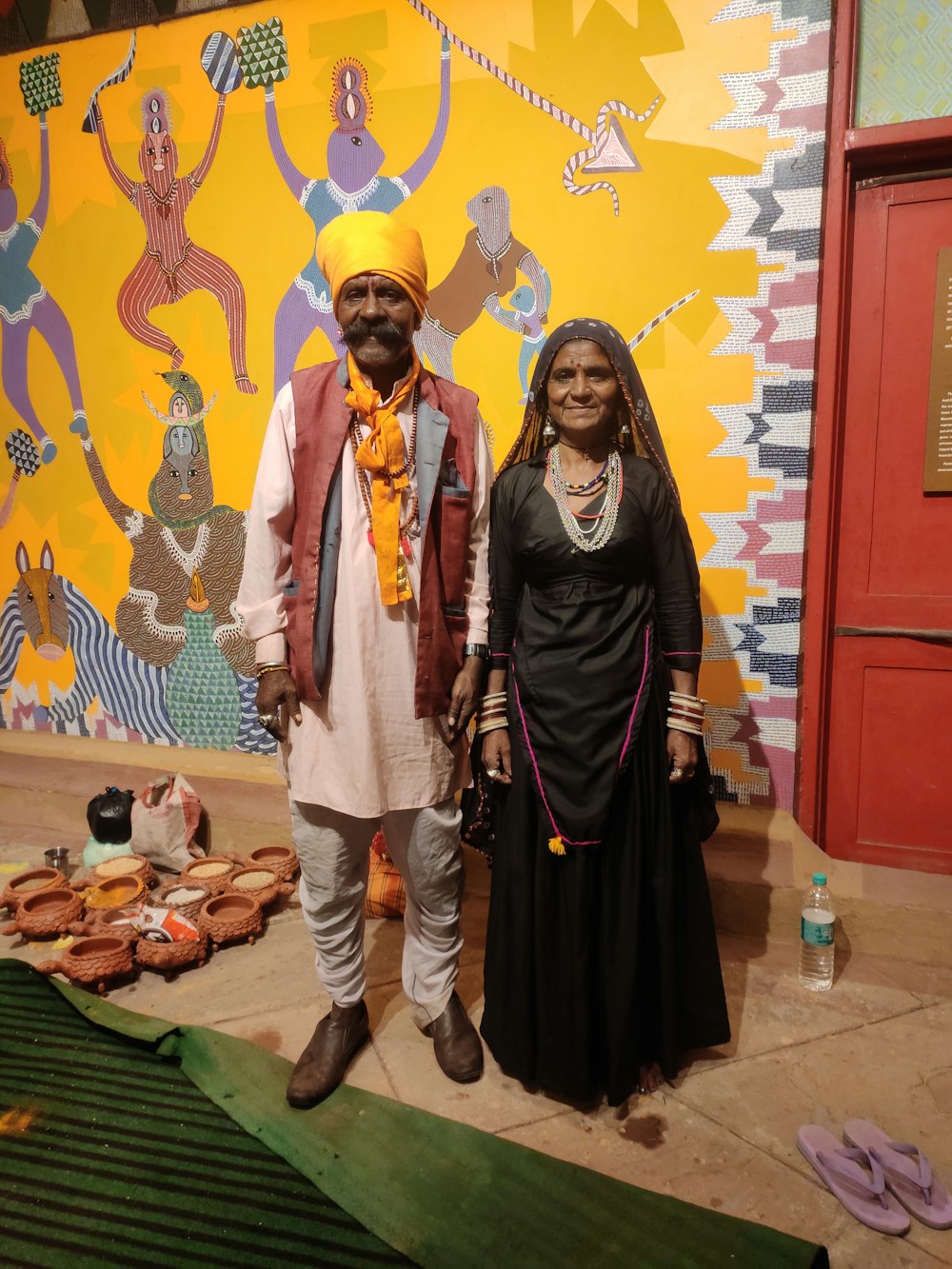 a man and a woman standing in front of a painting