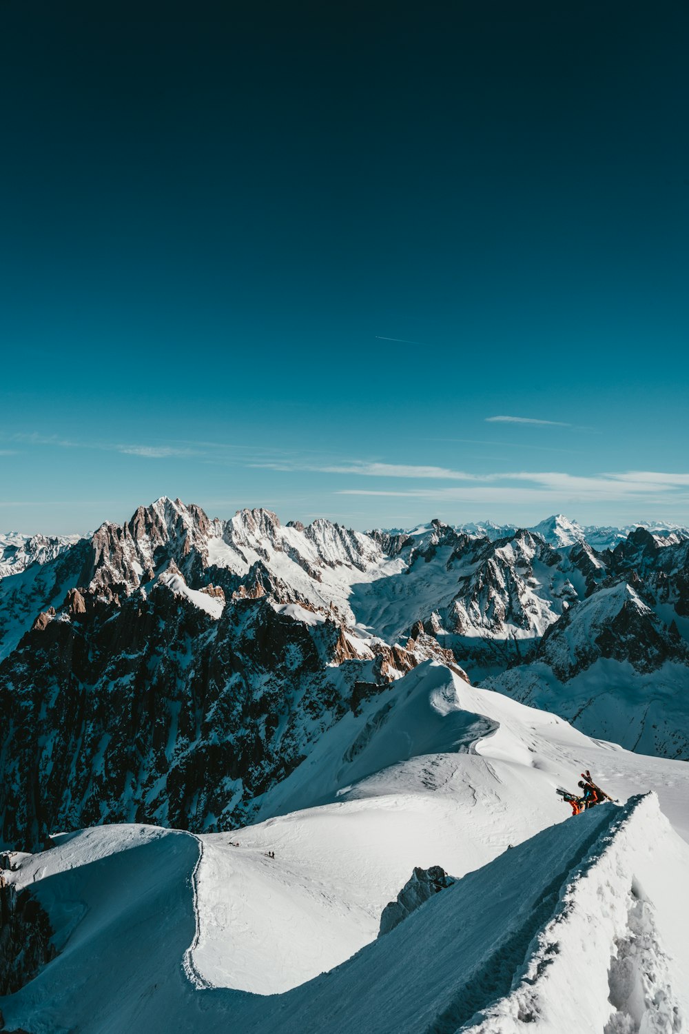 uma pessoa em pé no topo de uma montanha coberta de neve