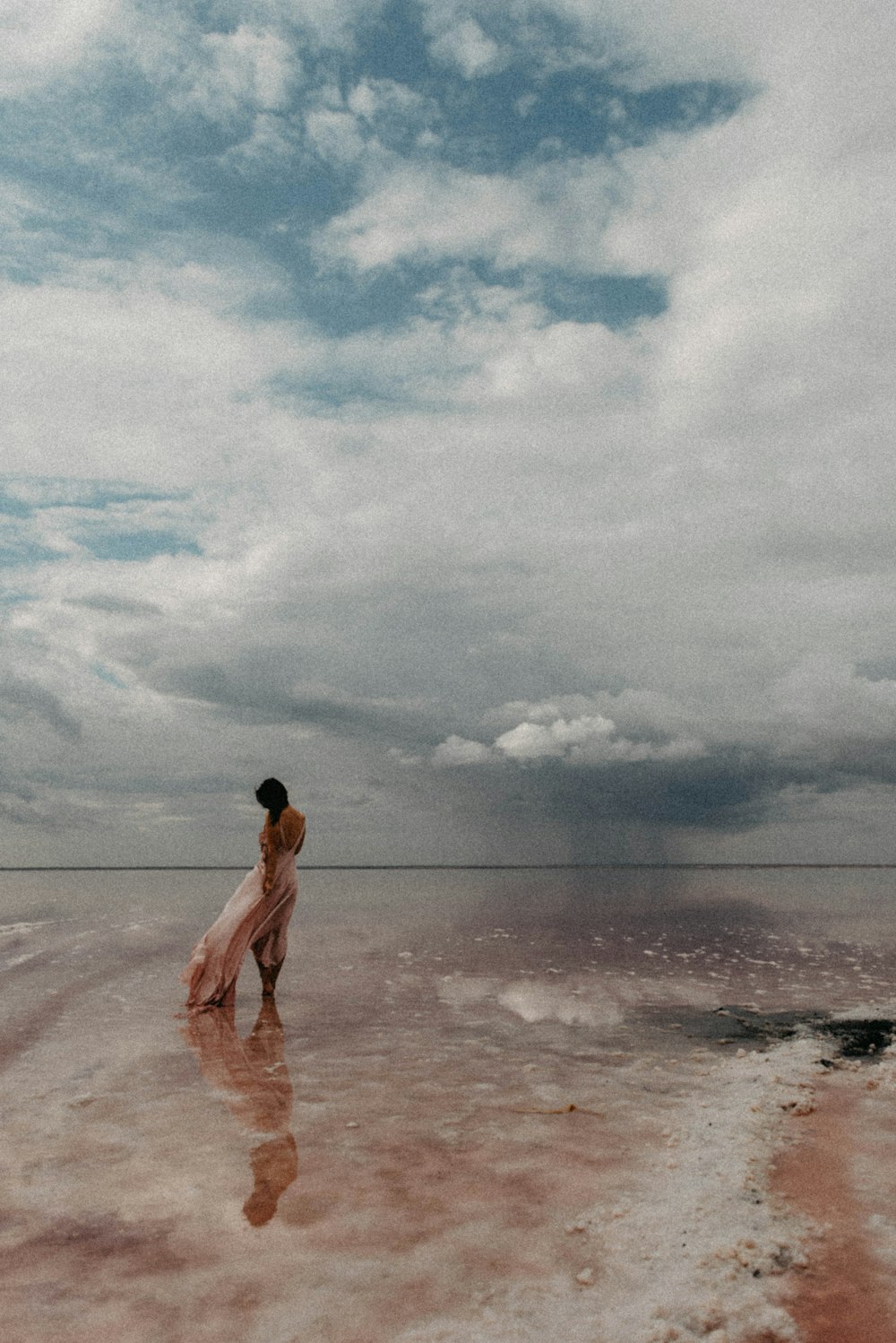 a woman standing in the middle of a desert