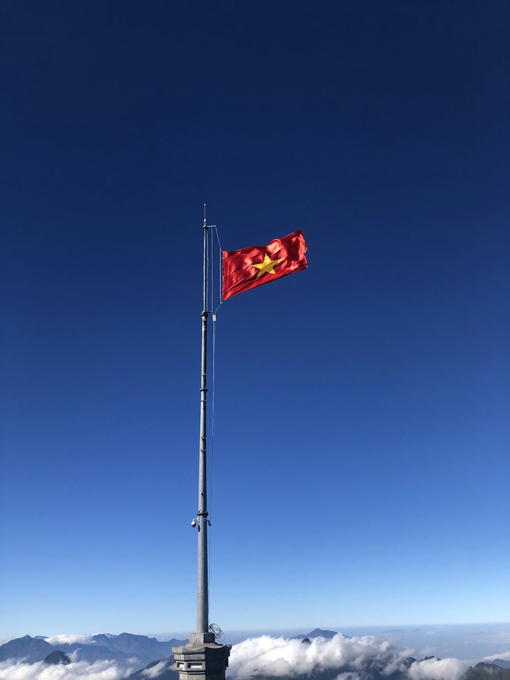 a red flag on top of a tall pole