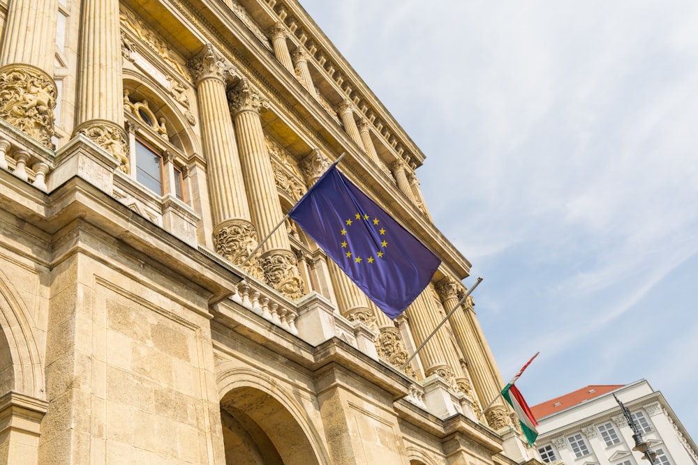 uma bandeira europeia hasteada na frente de um edifício