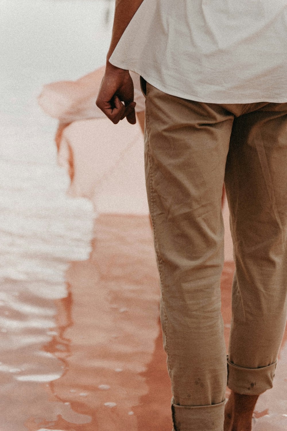 a man walking in the water holding an umbrella