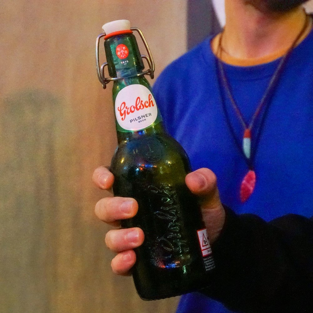 a person holding a beer bottle in their hand
