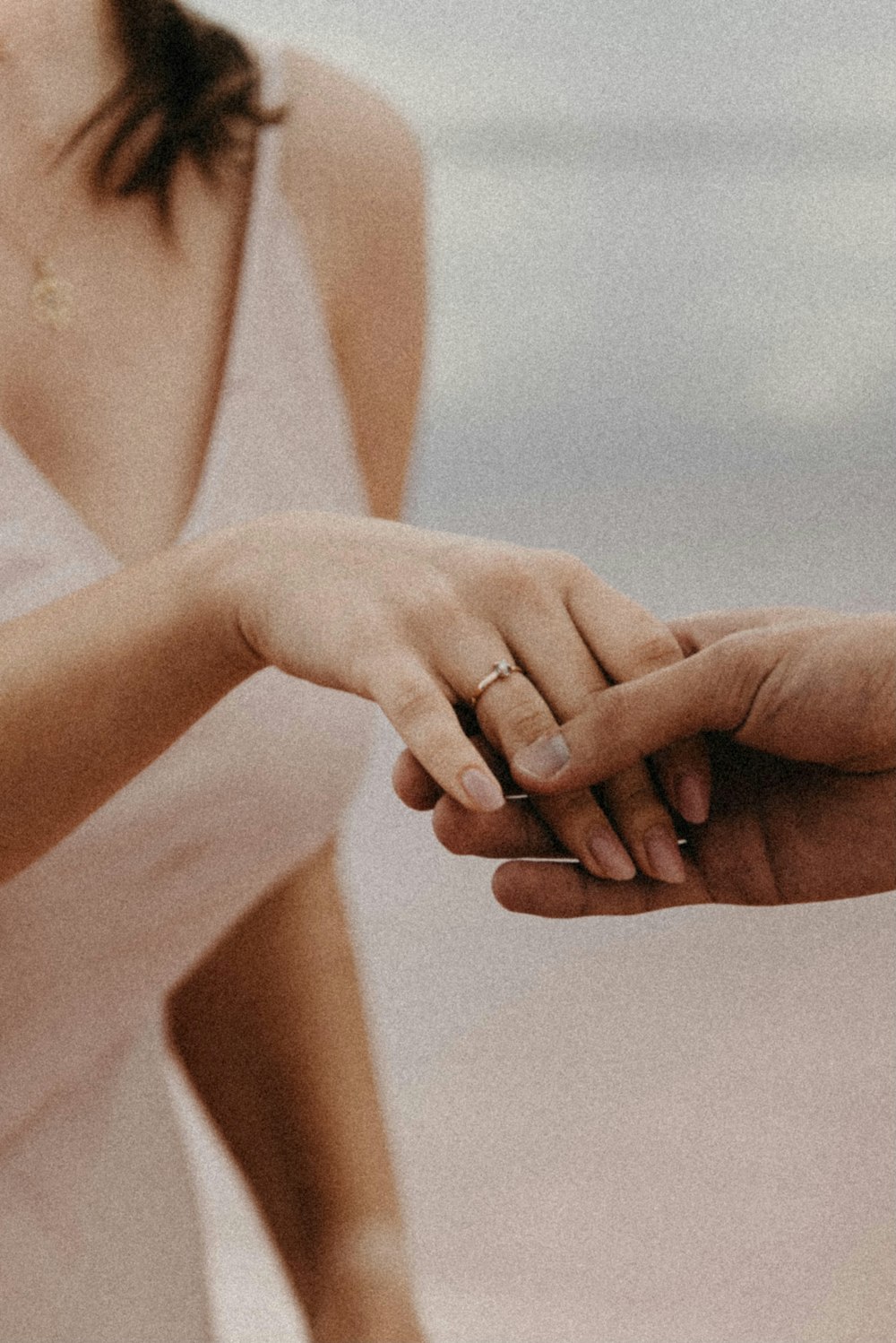 a man and a woman holding hands on the beach