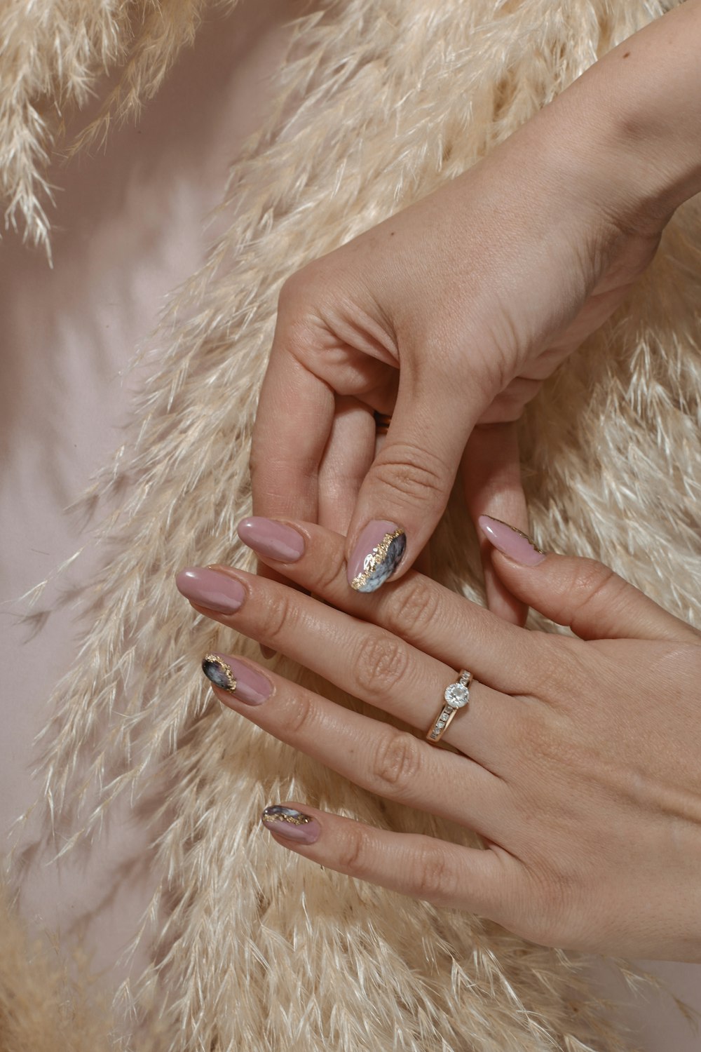 a woman's hands with a manicure and a ring