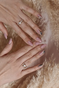 a woman's hands with manicured nails and a ring