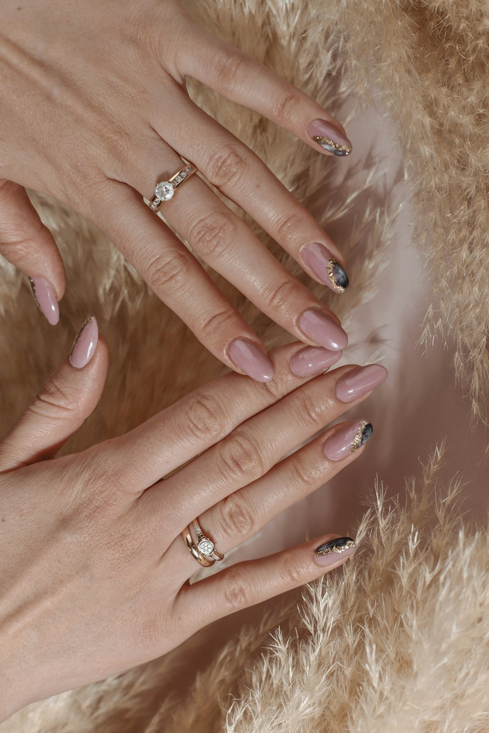 a woman's hands with manicured nails and a ring