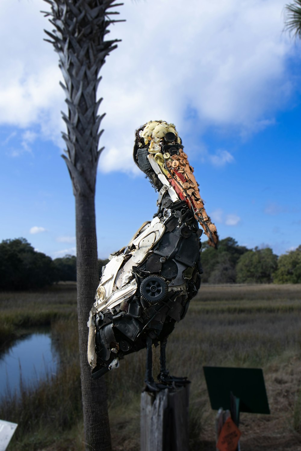 a bird made out of scraps sitting on top of a tree