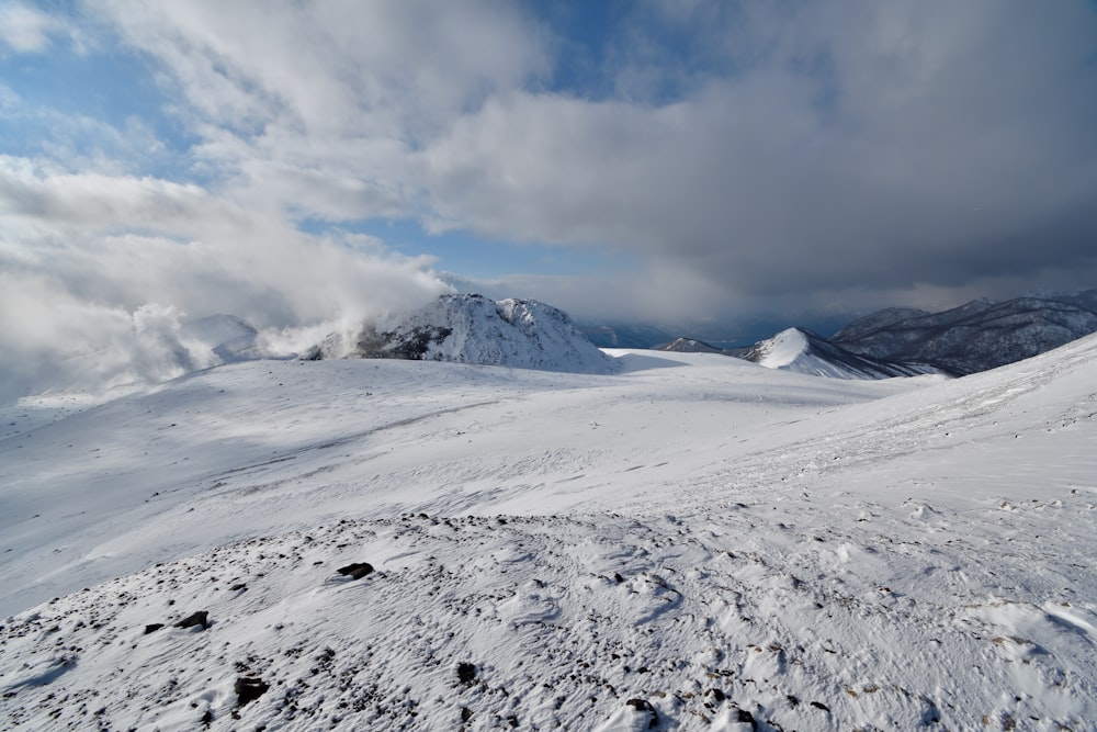 a snow covered mountain with clouds in the sky