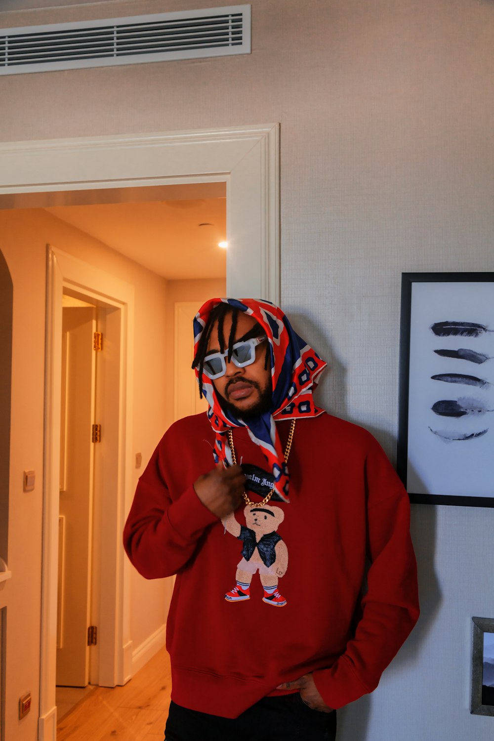 a man wearing a red sweatshirt and a scarf around his head